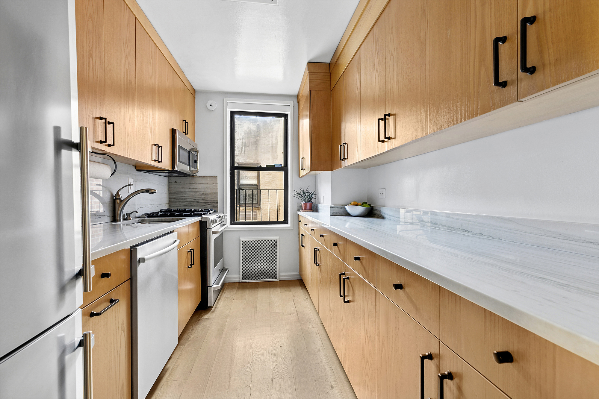 201 East 15th Street, Unit 7AJ Manhattan, NY 10003 - Photo 4 of 10 a kitchen with granite countertop white cabinets and white appliances