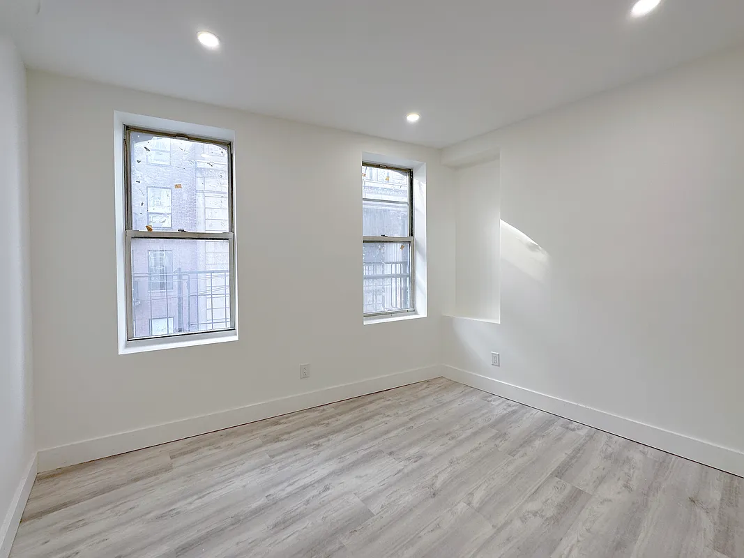55 Spring Street, Unit 7 Manhattan, NY 10012 - Photo 8 of 12 an empty room with wooden floor and windows