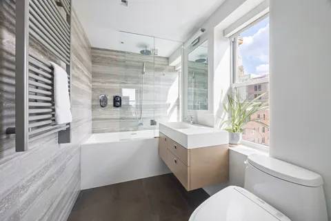 a bathroom with a sink a toilet a mirror and a bathtub