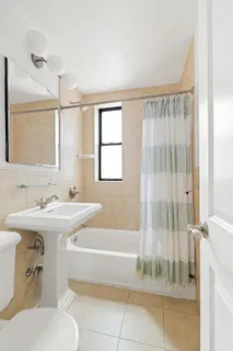 a bathroom with a tub sink and mirror