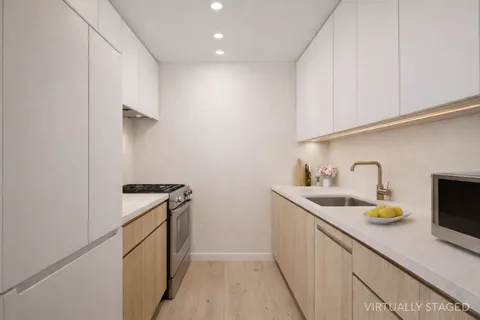 a kitchen with sink a stove and cabinets