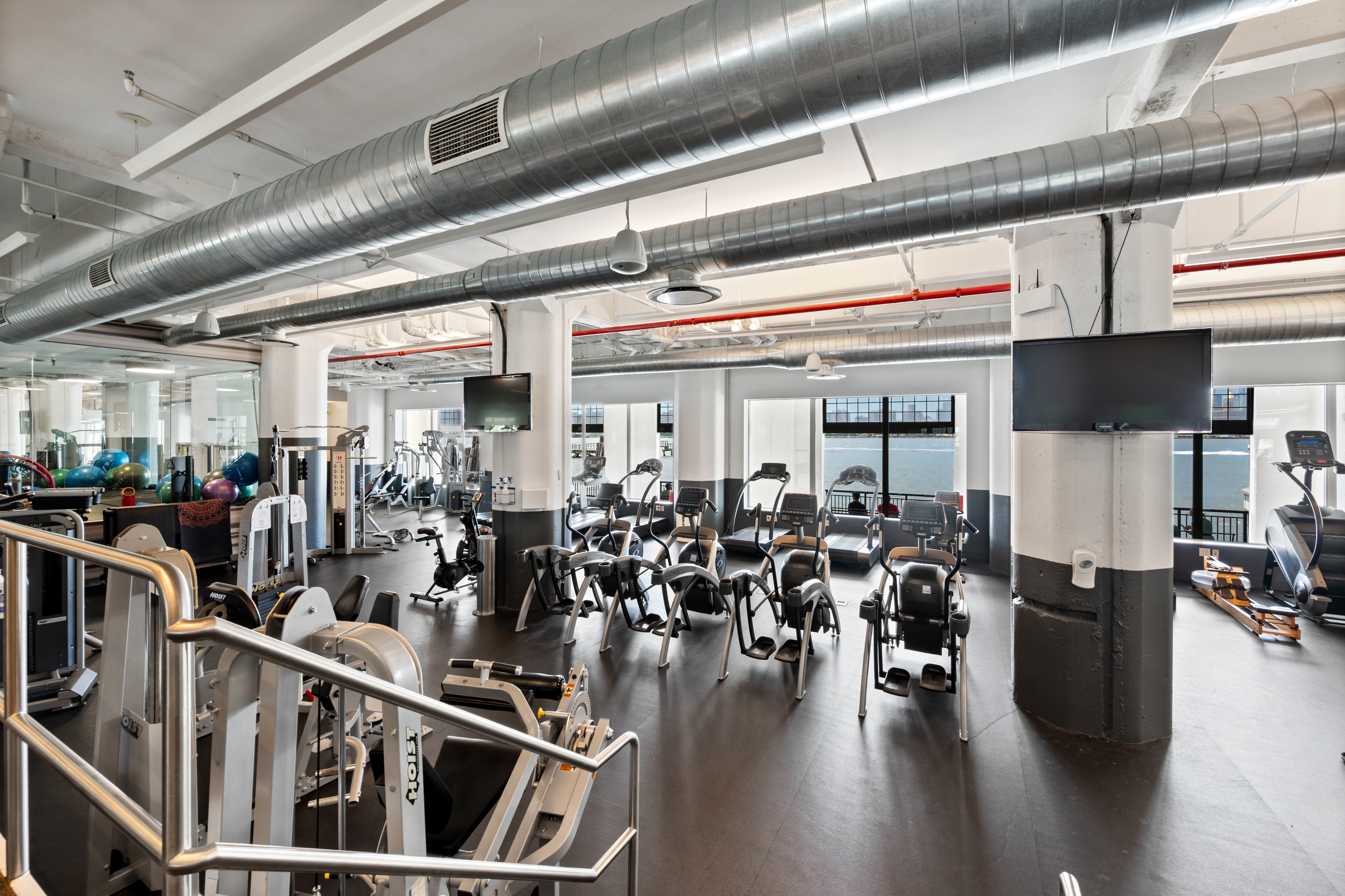 184 Kent Avenue, Unit C107 Brooklyn, NY 11249 - Photo 12 of 18 a room with lots of wooden furniture and stainless steel appliances