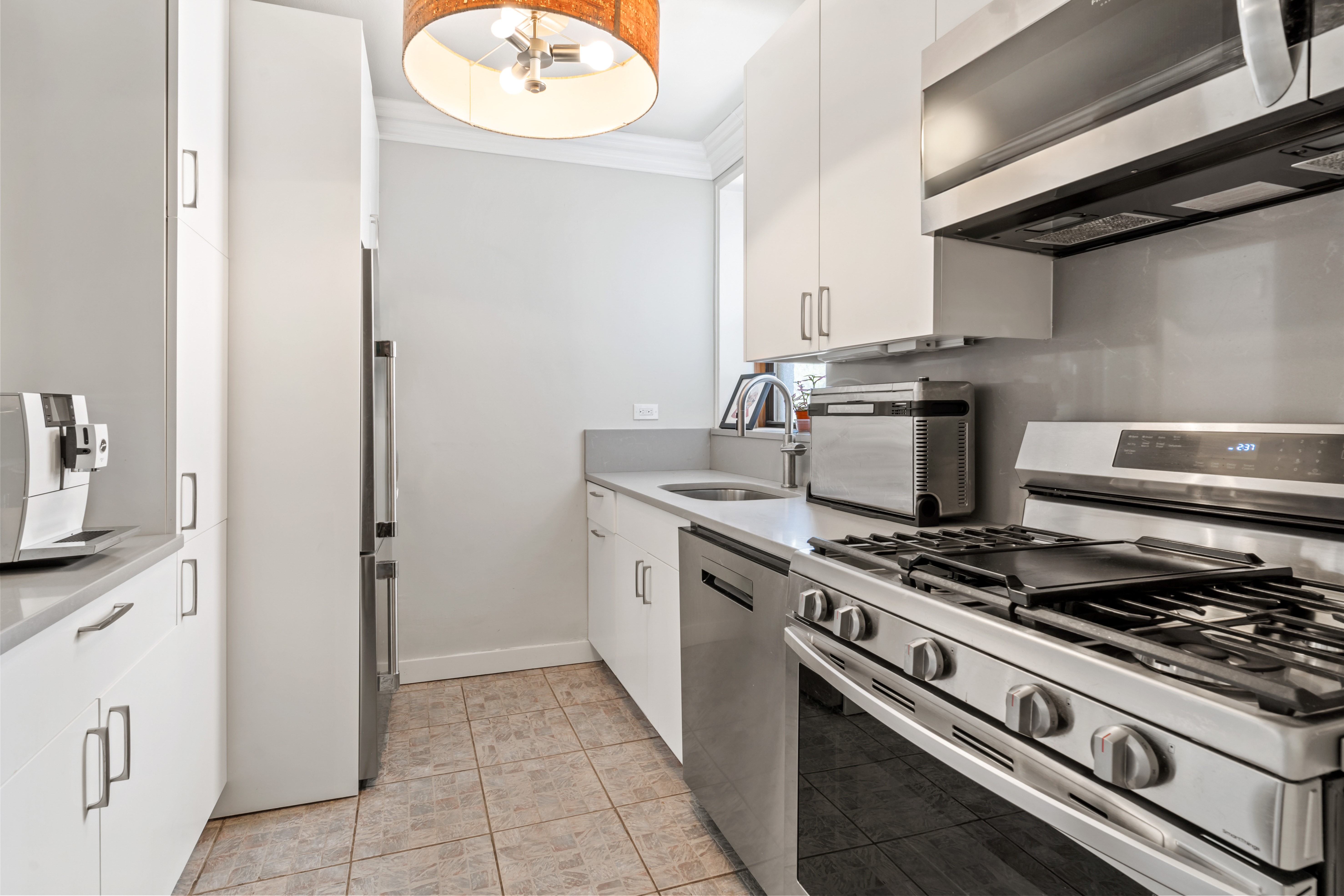 48-21 40th Street, Unit 1B Queens, NY 11104 - Photo 2 of 9 a kitchen with a stove and a microwave