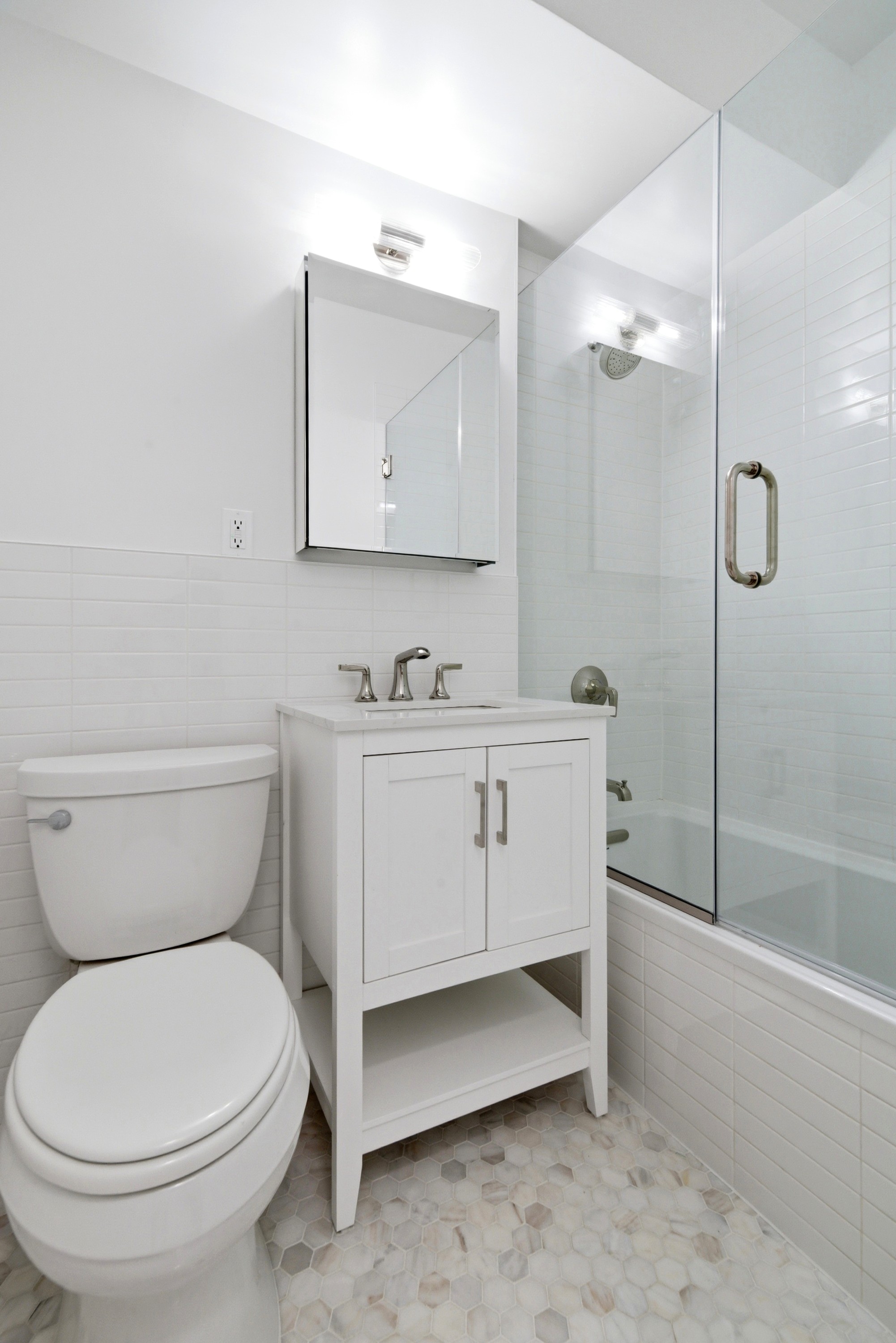 240 East 46th Street, Unit 8J Manhattan, NY 10017 - Photo 7 of 11 a bathroom with a toilet sink and mirror