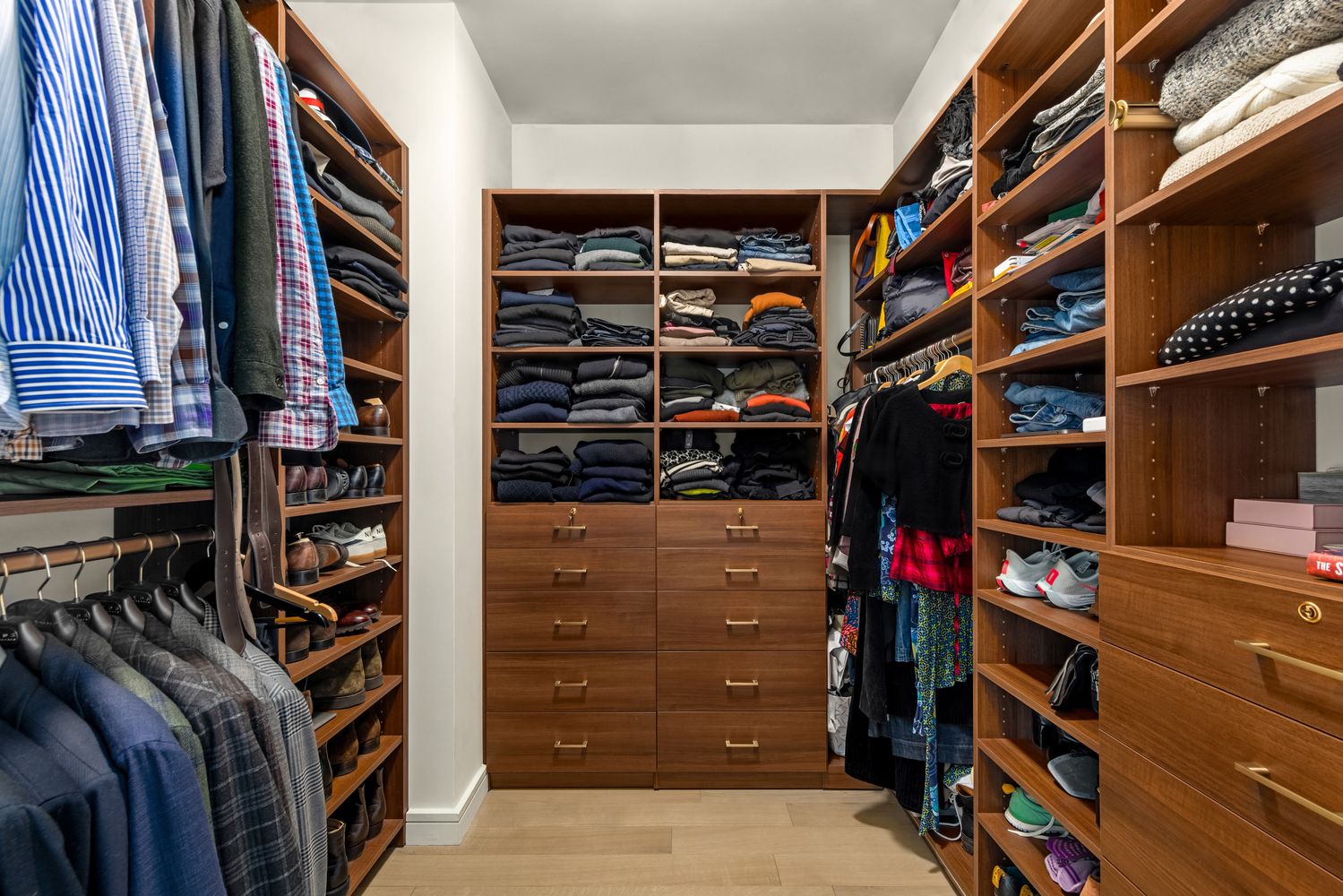 a view of walk in closet with clothes and shoes