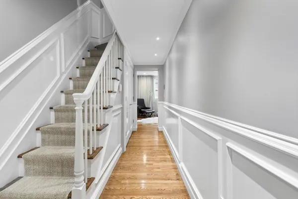 a view of a hallway with wooden floor and staircase