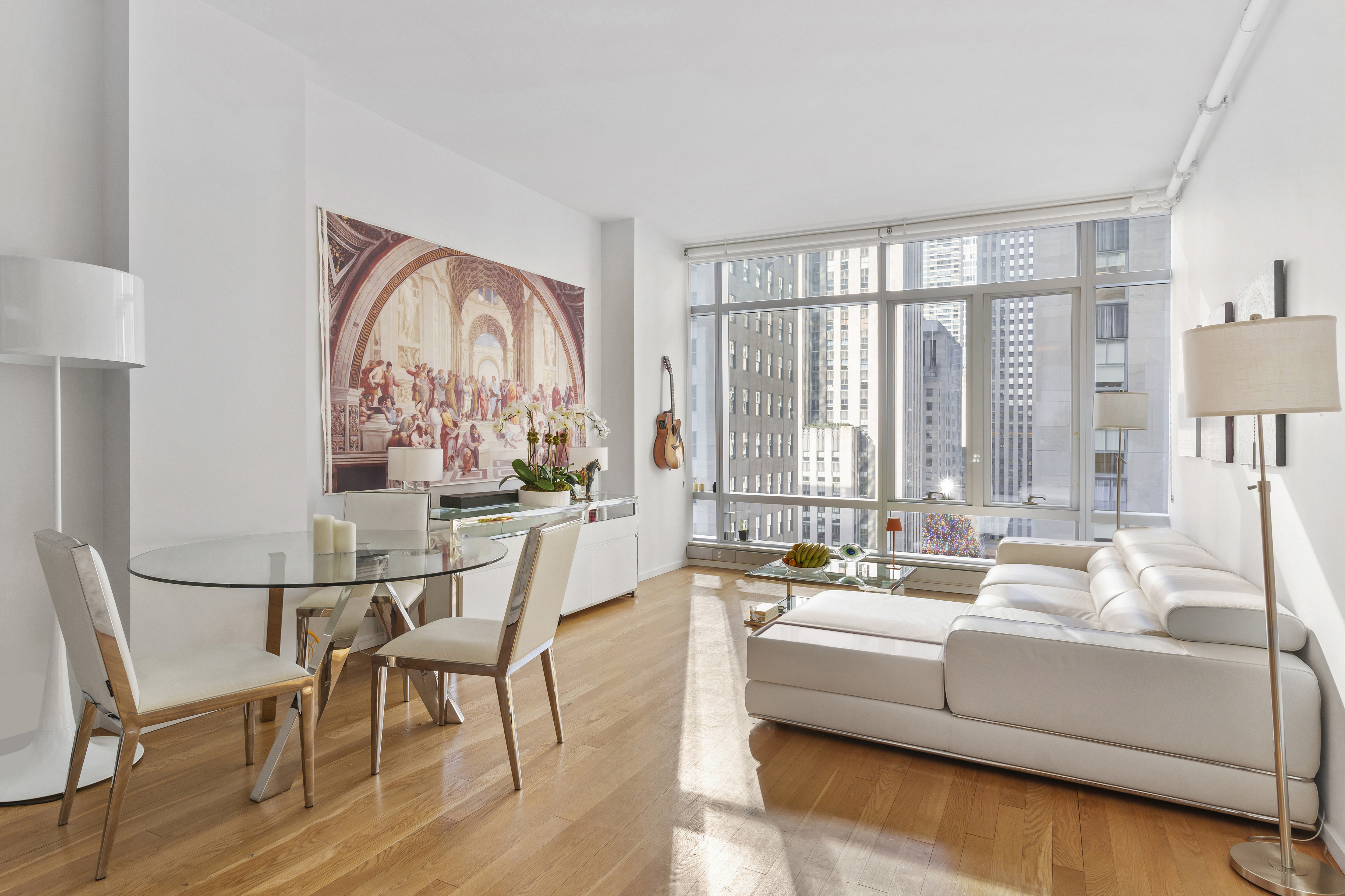 18 West 48th Street, Unit 10E Manhattan, NY 10036 - Photo 1 of 10 a living room with furniture and large windows