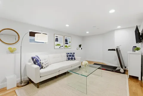 a living room with furniture a flat screen tv and a window