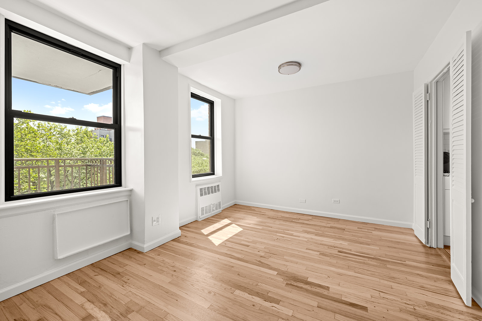 540 Ocean Parkway, Unit 5R Brooklyn, NY 11218 - Photo 3 of 11 a view of an empty room with wooden floor and a window