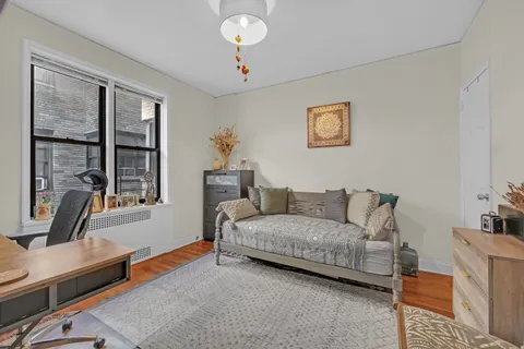 a living room with a bed furniture and a large window