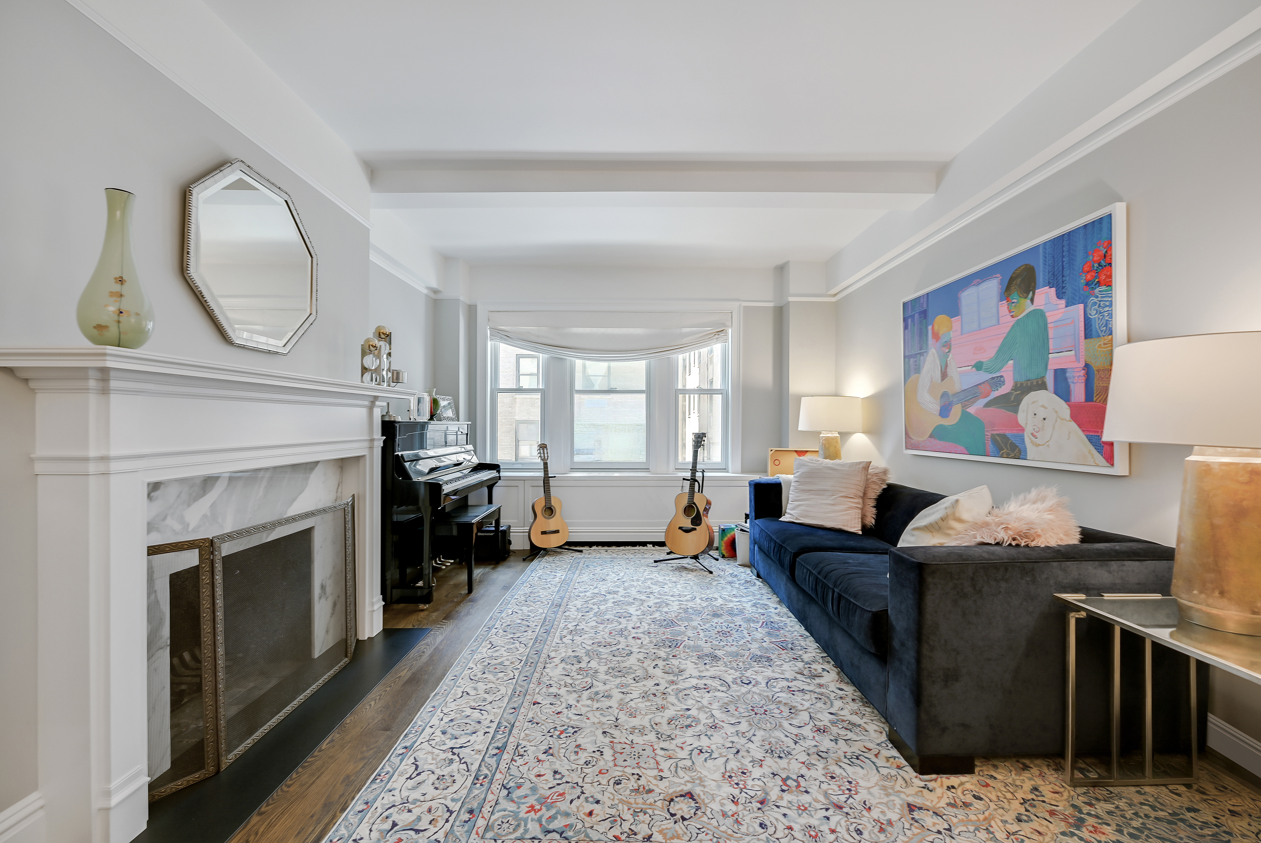 7 East 85th Street, Unit 5AB Manhattan, NY 10028 - Photo 2 of 12 a living room with furniture a fireplace and a flat screen tv