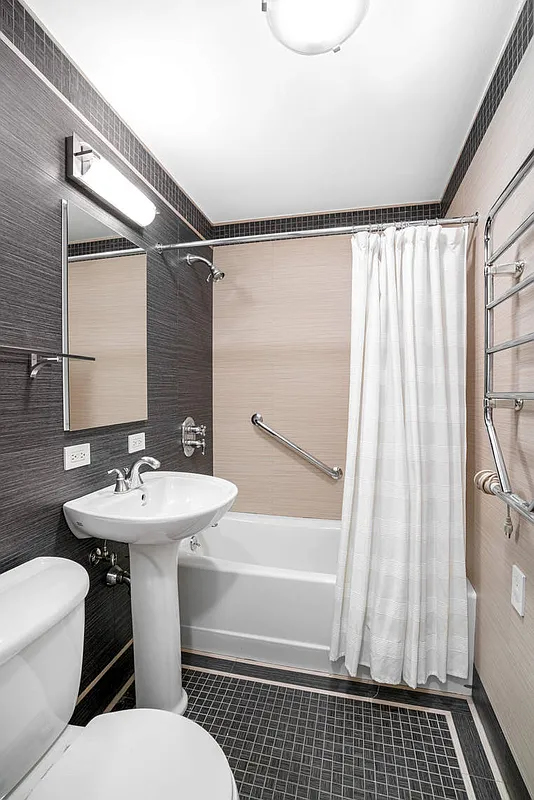 333 East 66th Street, Unit 2FE Manhattan, NY 10065 - Photo 11 of 19 a bathroom with a sink a toilet a mirror and shower