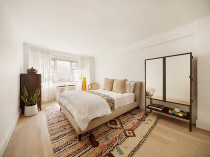 a spacious bedroom with a bed and a large mirror