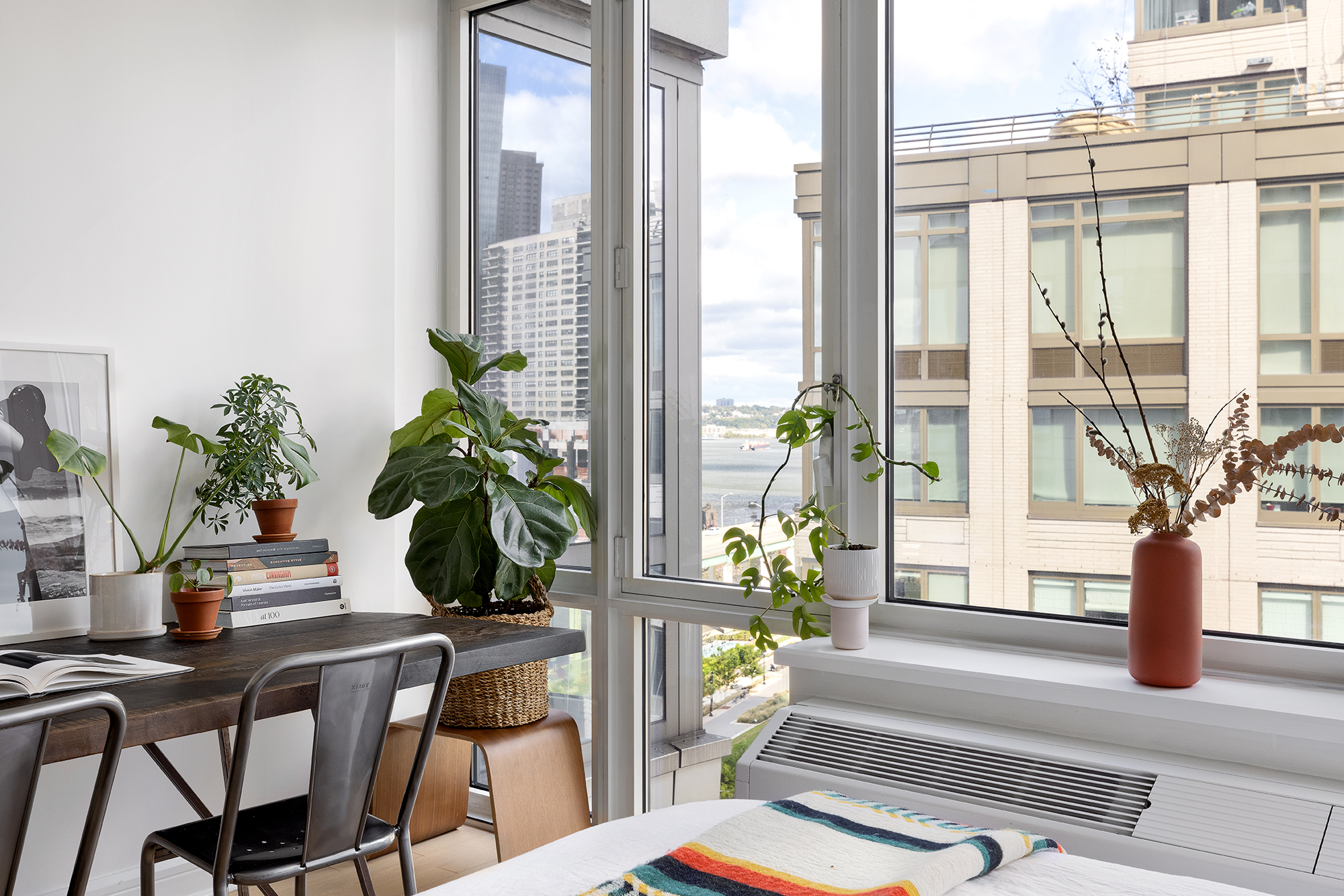 80 Riverside Boulevard, Unit 12D Manhattan, NY 10069 - Photo 8 of 16 a dining room with furniture potted plants and wooden floor
