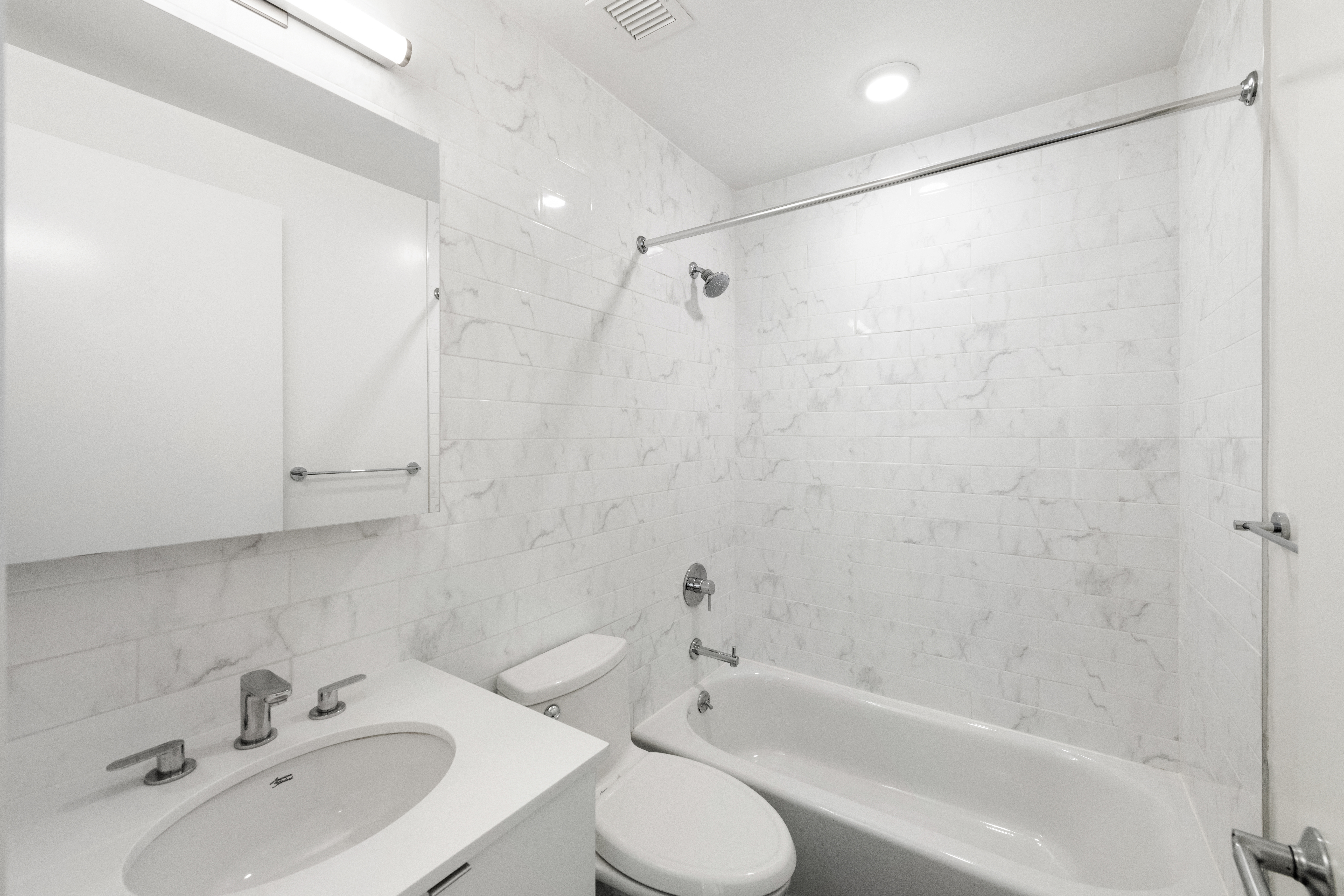 1168 Greene Avenue, Unit 2B Brooklyn, NY 11221 - Photo 4 of 11 a bathroom with a bathtub shower sink vanity and toilet