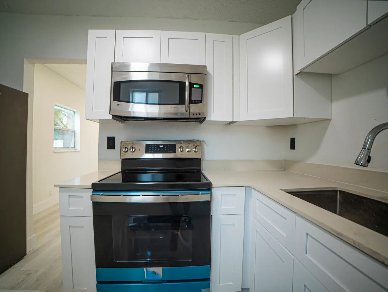 a kitchen with white cabinets and stainless steel appliances