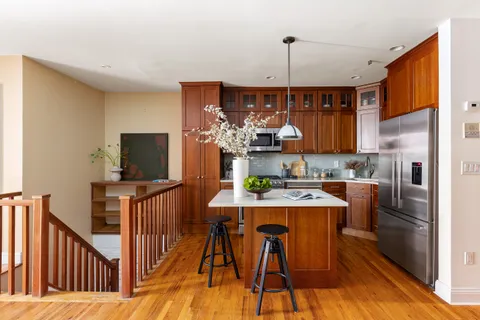 a kitchen with stainless steel appliances granite countertop a refrigerator a stove top oven a sink dishwasher and wooden floor