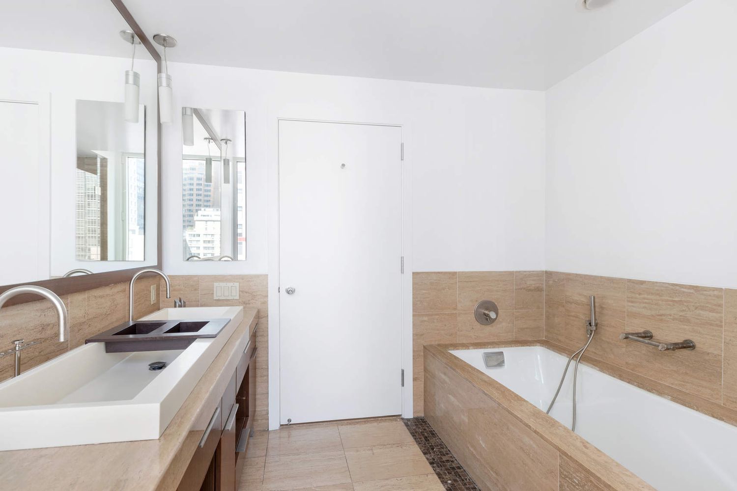 250 East 53rd Street, Unit 1001 Manhattan, NY 10022 - Photo 8 of 18 a bathroom with a tub sink and mirror