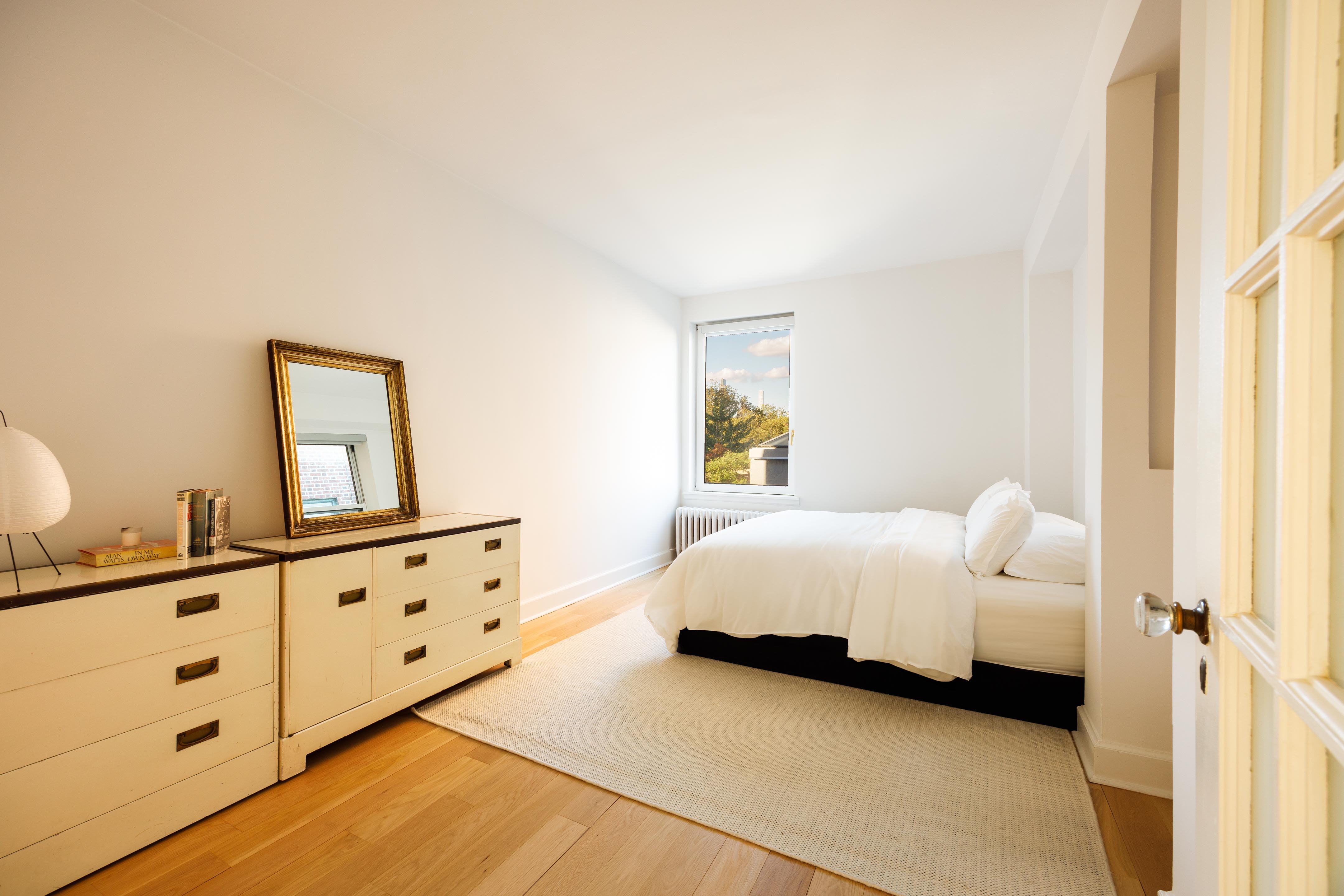 131 Avenue B, Unit 5C Manhattan, NY 10009 - Photo 11 of 18 a spacious bedroom with a bed a window and dresser