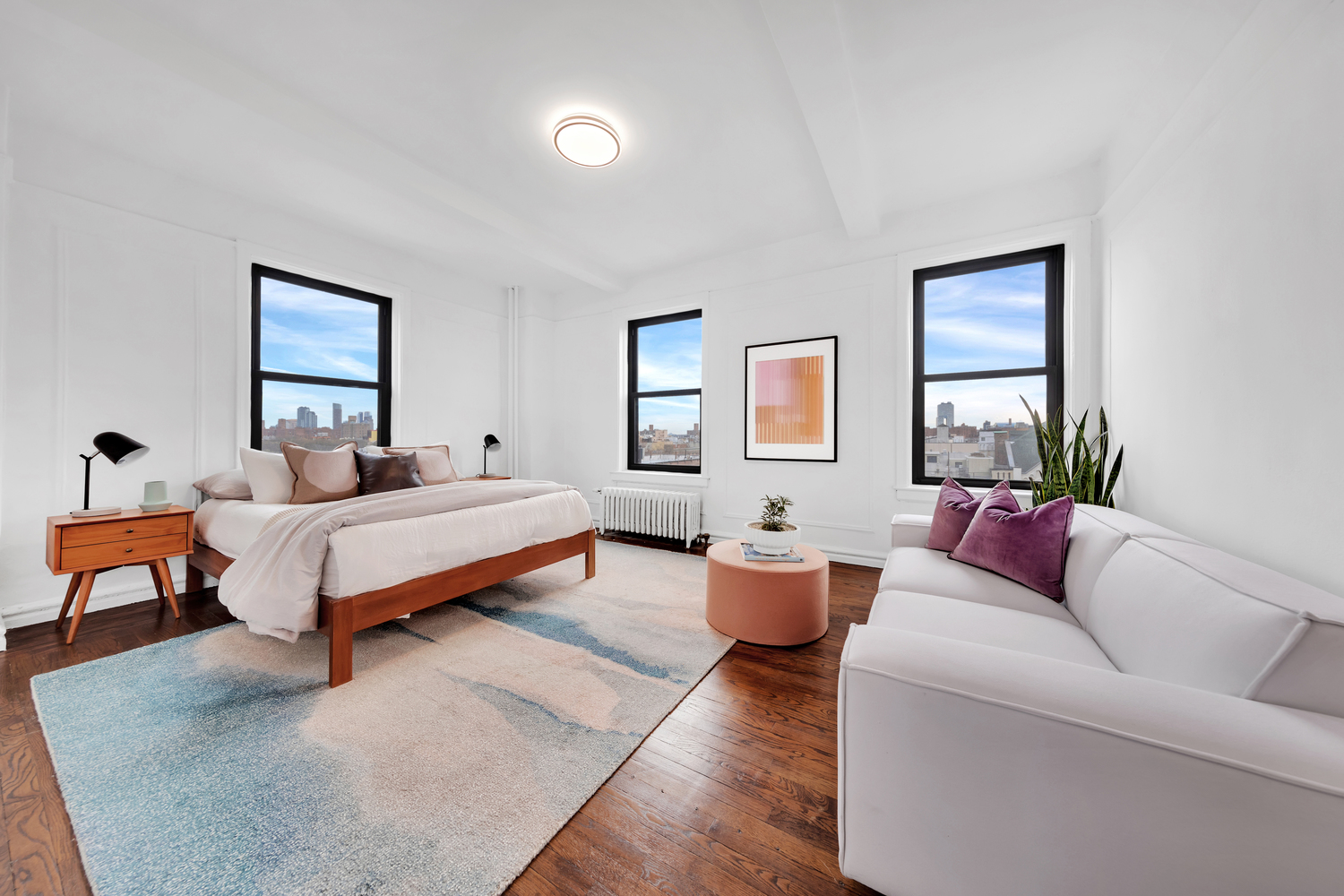 172 East 4th Street, Unit 8F Manhattan, NY 10009 - Photo 5 of 11 a spacious bedroom with a large bed couch and windows