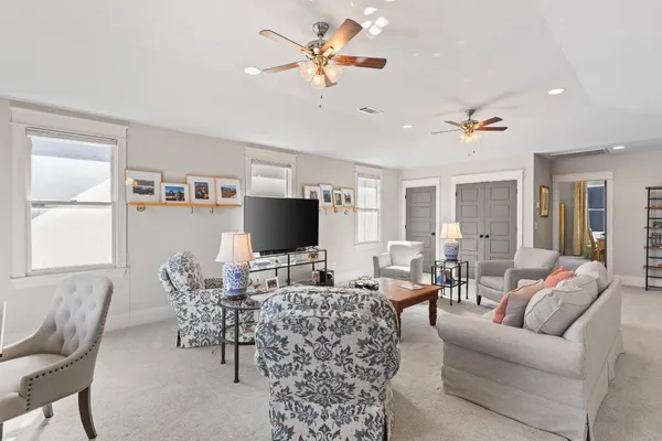 a living room with furniture a chandelier and a flat screen tv
