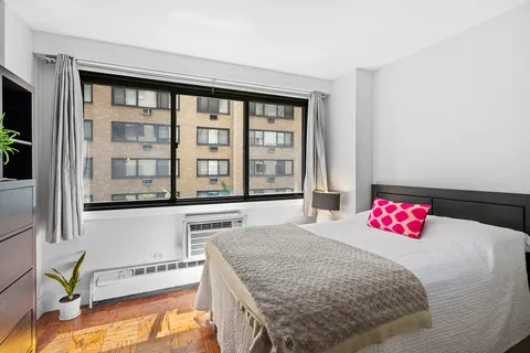 a bedroom with a bed and a large window