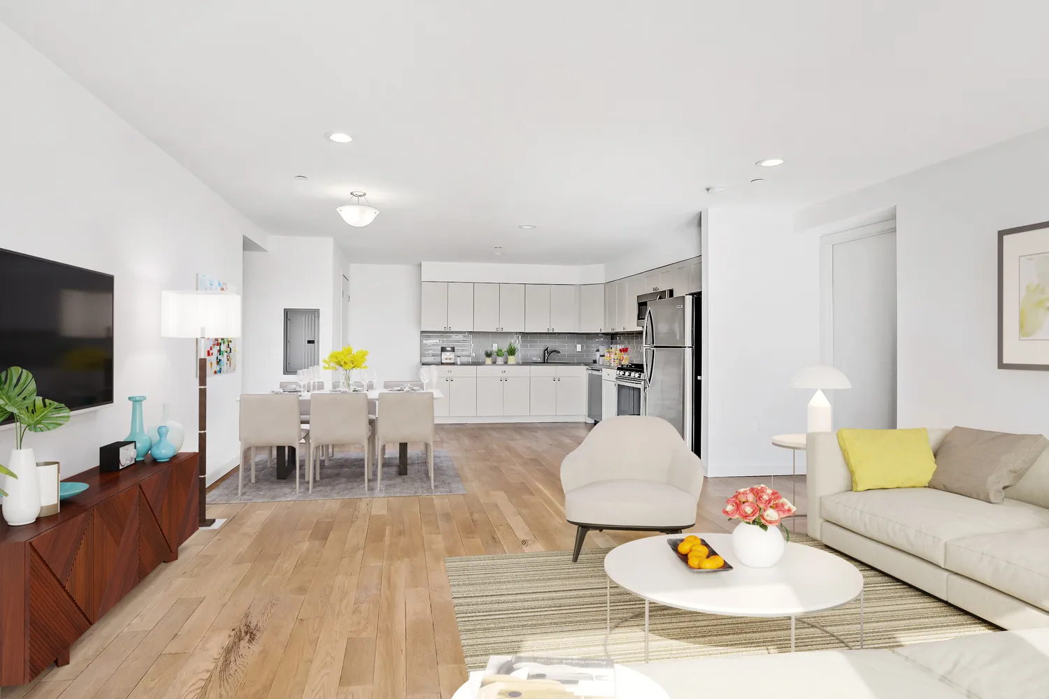 a living room with stainless steel appliances furniture and wooden floor