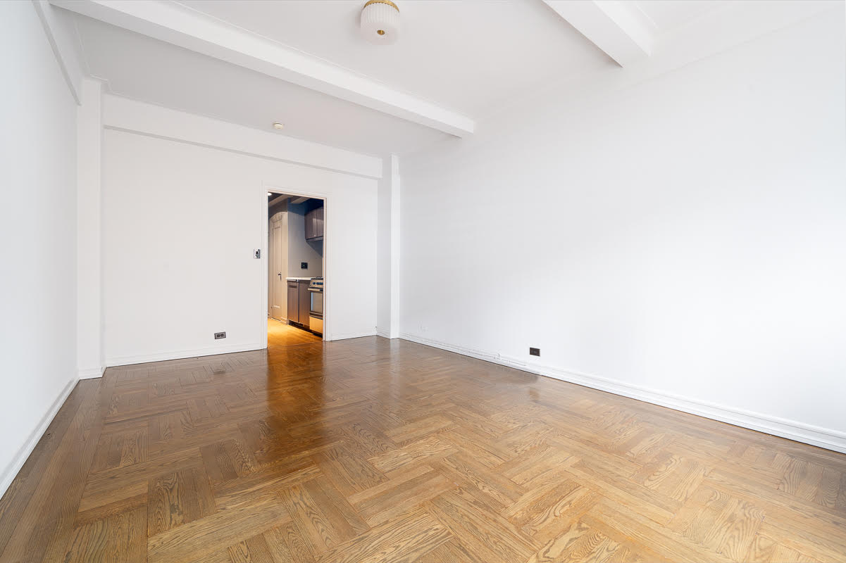 433 West 34th Street, Unit 9E Manhattan, NY 10001 - Photo 2 of 10 an empty room with wooden floor and windows
