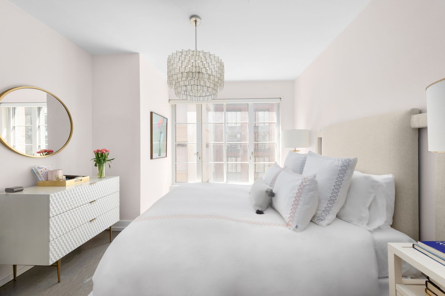 70 Charlton Street, Unit 19D Manhattan, NY 10014 - Photo 6 of 14 a bedroom with a large bed and a chandelier
