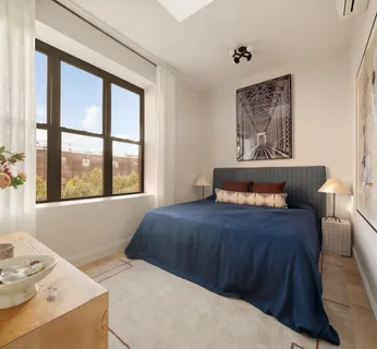 a bed sitting in a bedroom next to a window