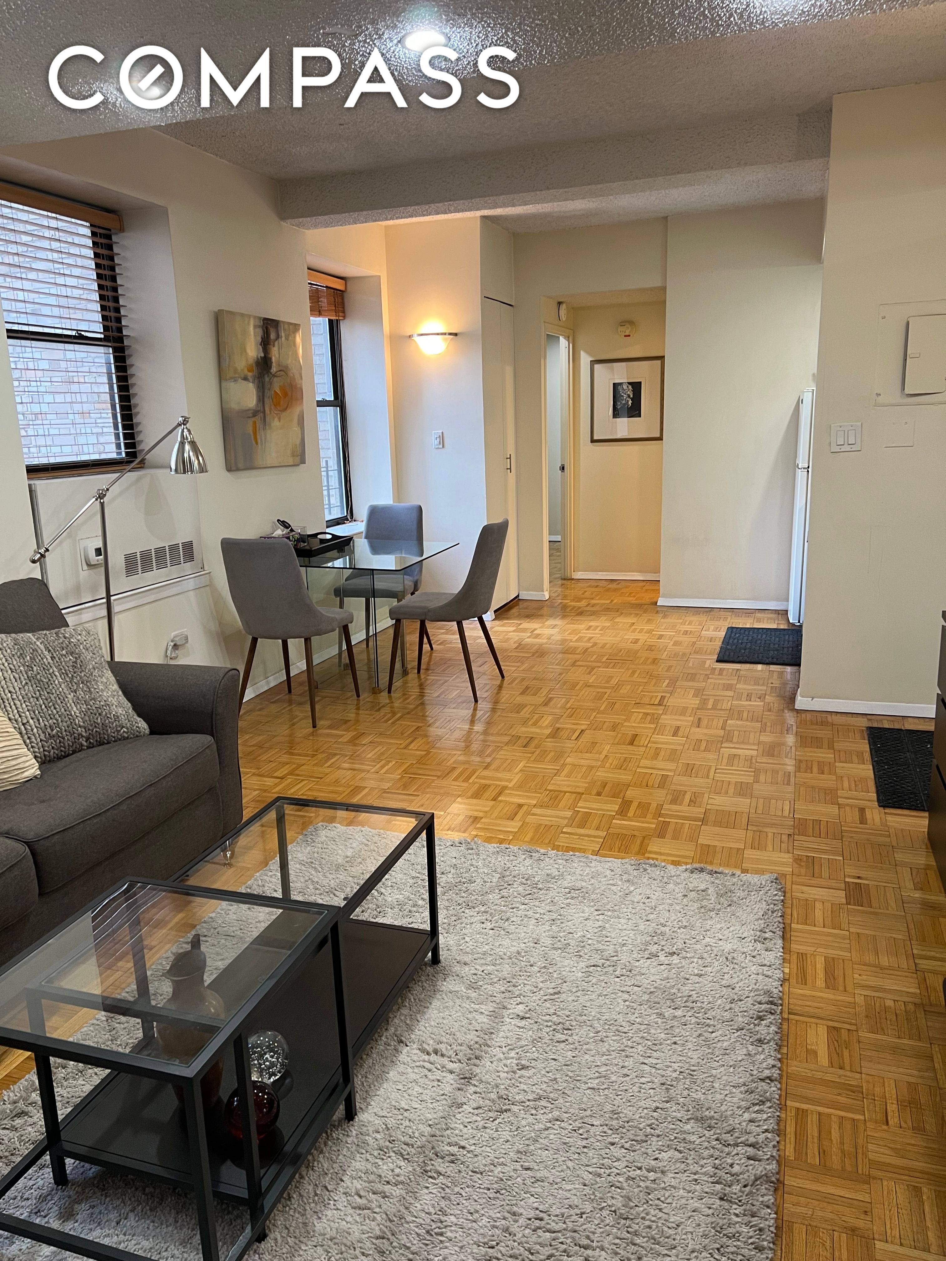 150 West 51st Street, Unit 1909 Manhattan, NY 10019 - Photo 3 of 12 a living room with furniture and a table