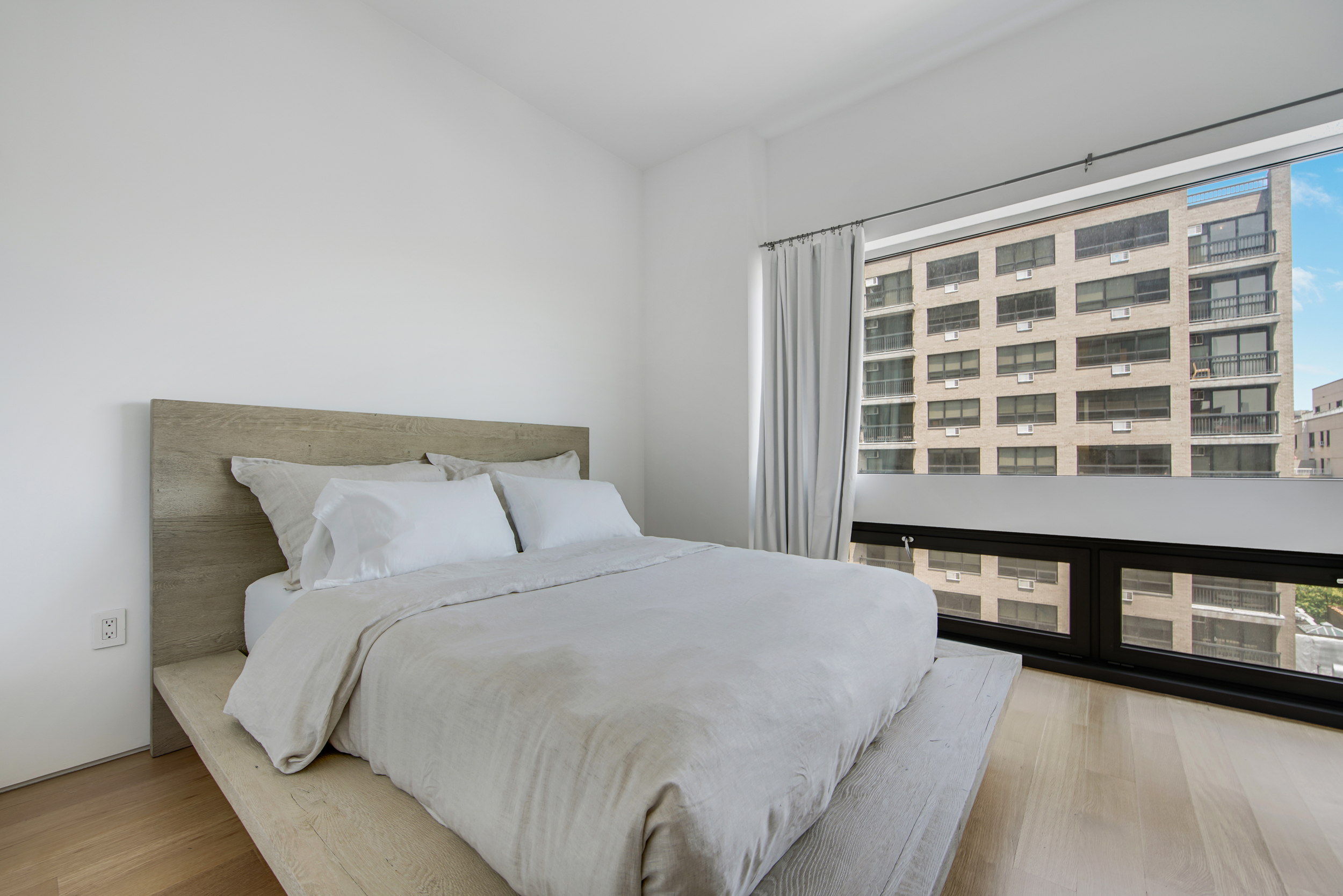 123 3rd Avenue, Unit 9C Manhattan, NY 10003 - Photo 8 of 16 a large bed sitting in a bedroom next to a lamp