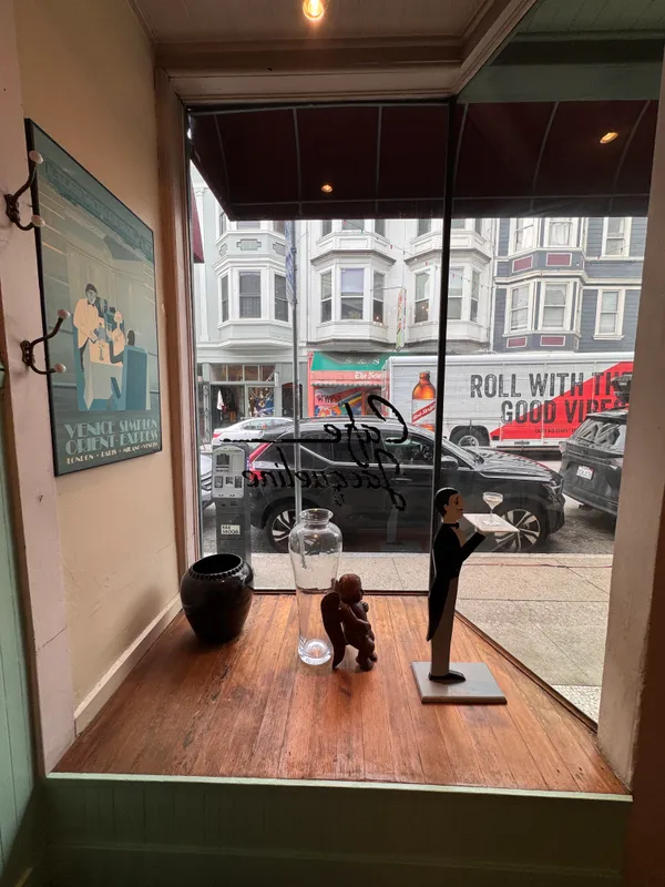 a view of a dining room with furniture a chandelier and a window