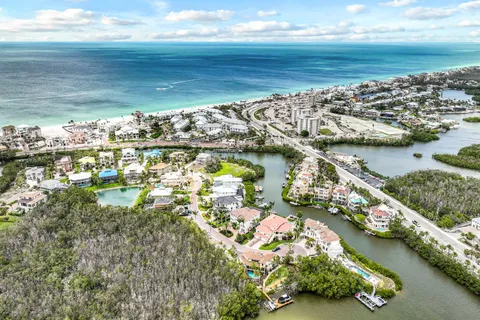 an aerial view of ocean and residential houses with outdoor space