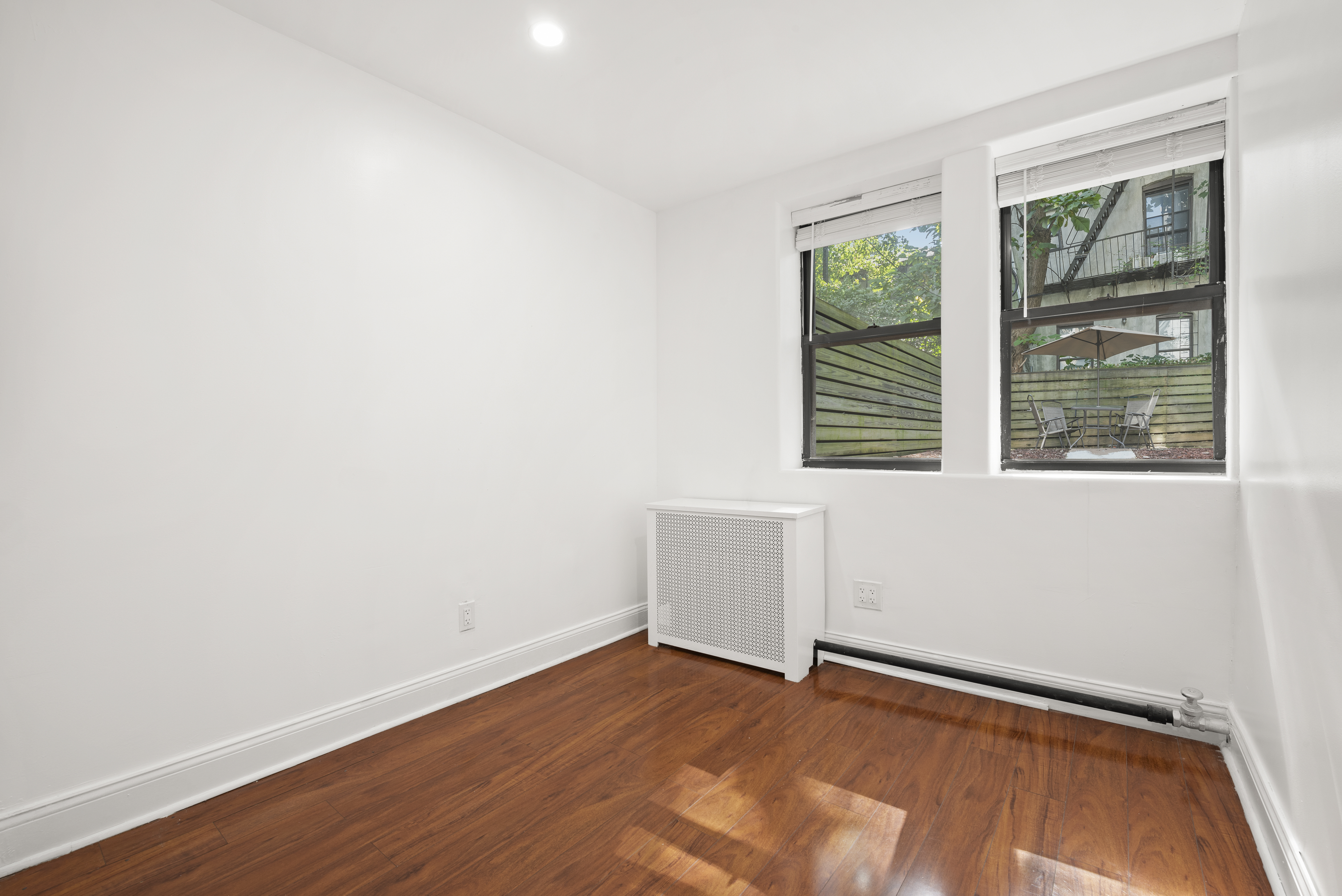 654 Lafayette Avenue, Unit GARDENA Brooklyn, NY 11216 - Photo 6 of 14 a view of an empty room with wooden floor and a window
