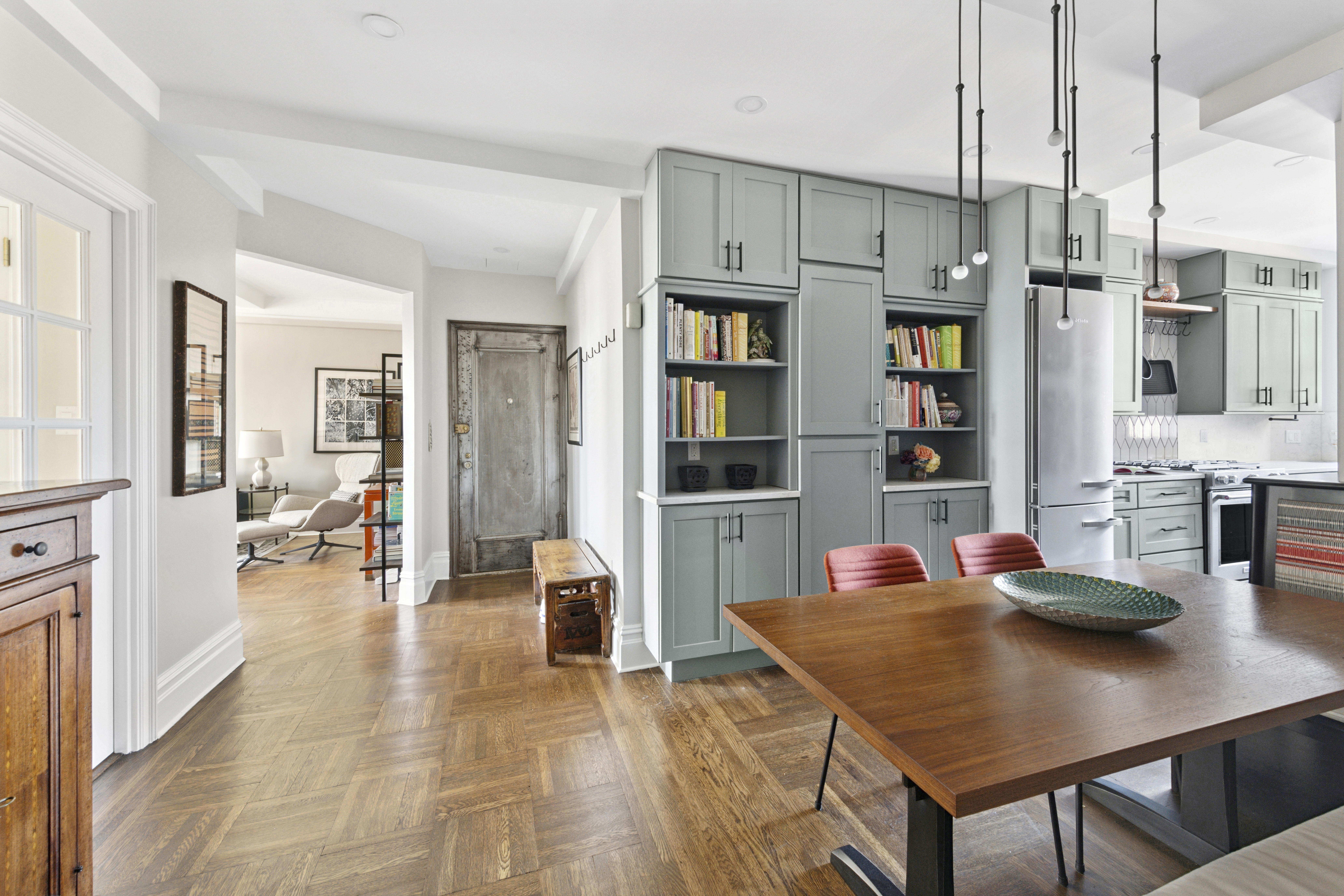 245 West 104th Street, Unit 16C Manhattan, NY 10025 - Photo 3 of 16 a open dining room with stainless steel appliances kitchen island granite countertop a table chairs and a refrigerator