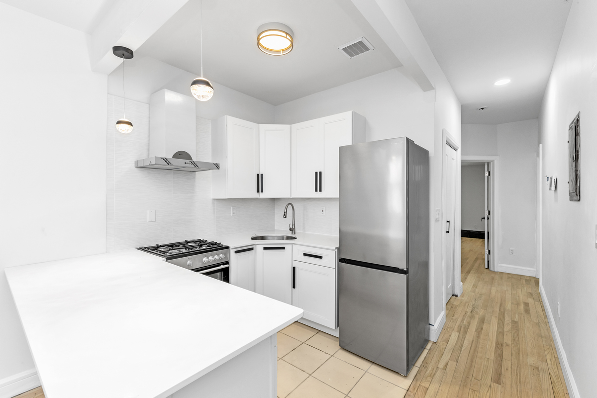574 Gates Avenue Brooklyn, NY 11221 - Photo 3 of 16 a kitchen with stainless steel appliances a refrigerator and a stove
