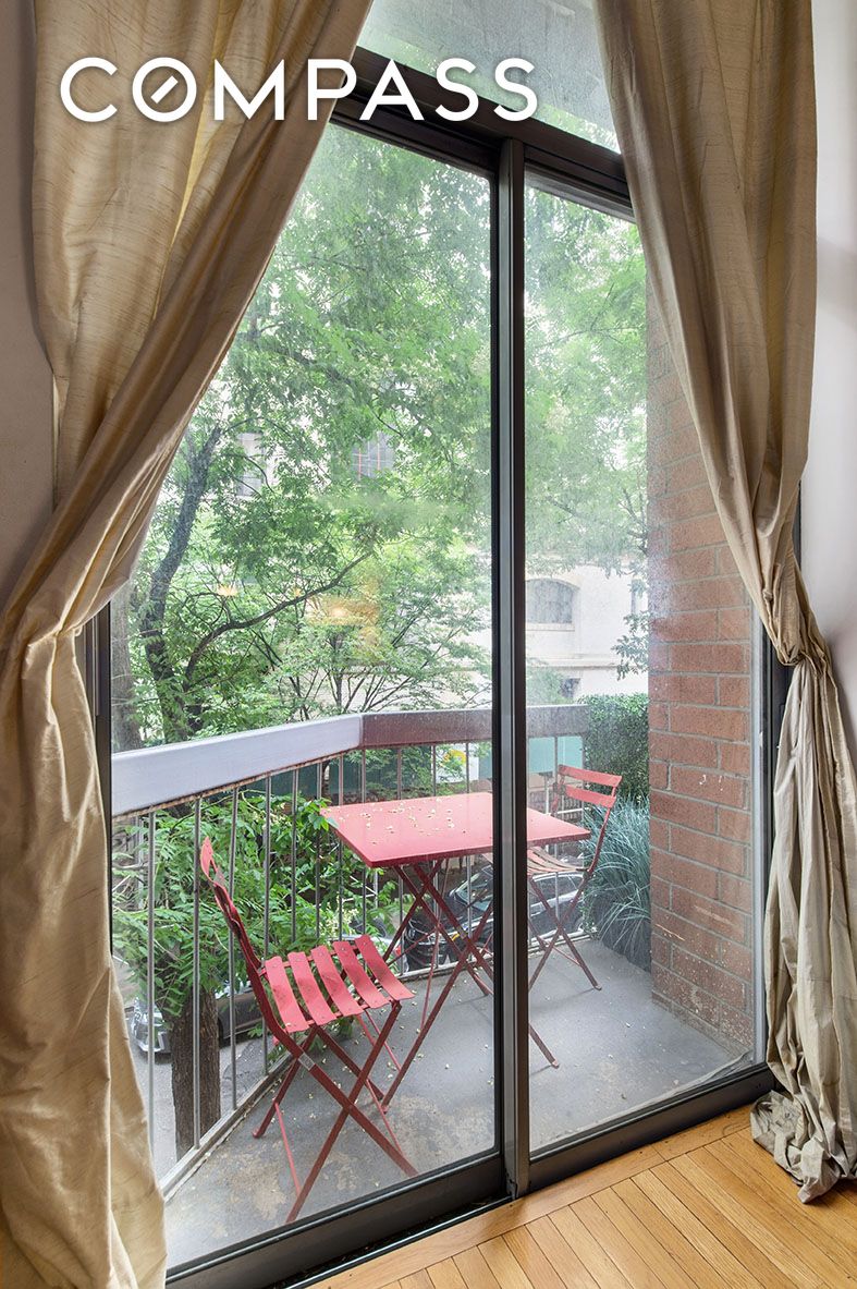 184 Thompson Street, Unit 1E Manhattan, NY 10012 - Photo 7 of 8 a view of a floor to ceiling window with wooden floor