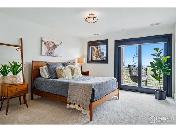 a spacious bedroom with a bed a couch and a potted plant