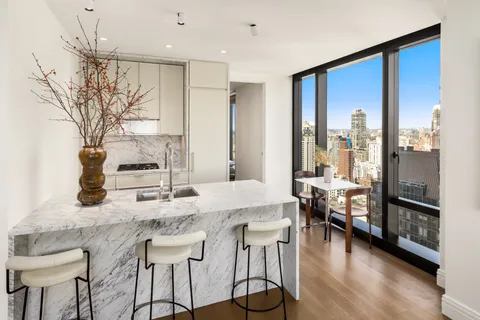 a kitchen with granite countertop a table chairs stove and wooden floor