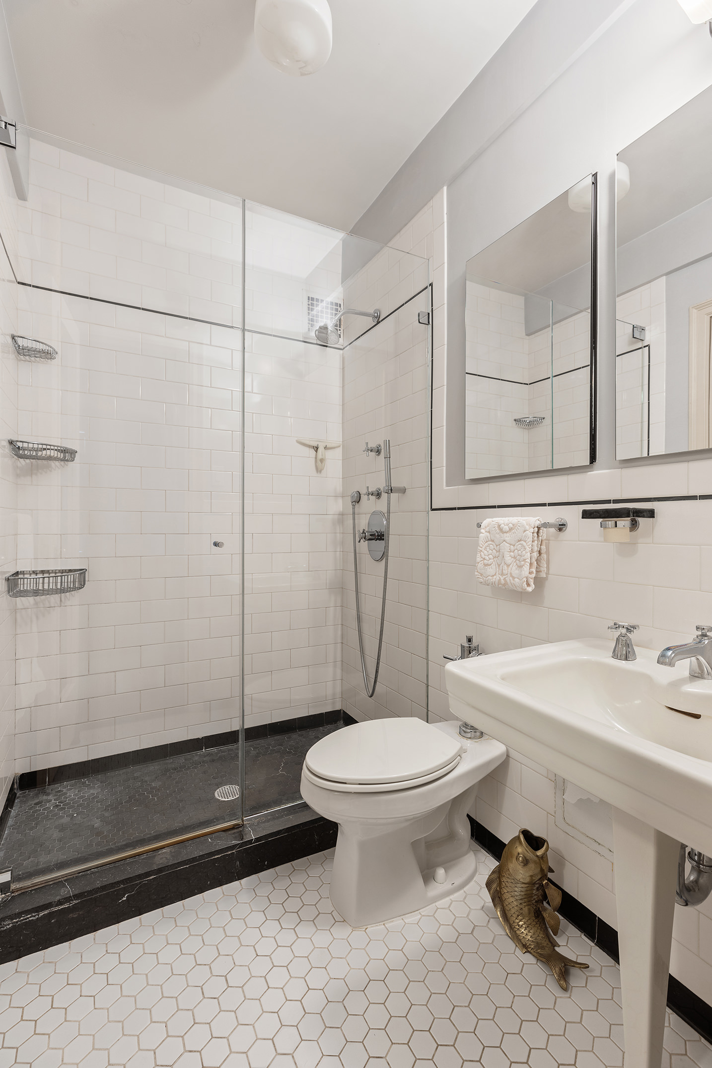 200 East 16th Street, Unit 19D Manhattan, NY 10003 - Photo 11 of 14 a bathroom with a sink a toilet a mirror and shower
