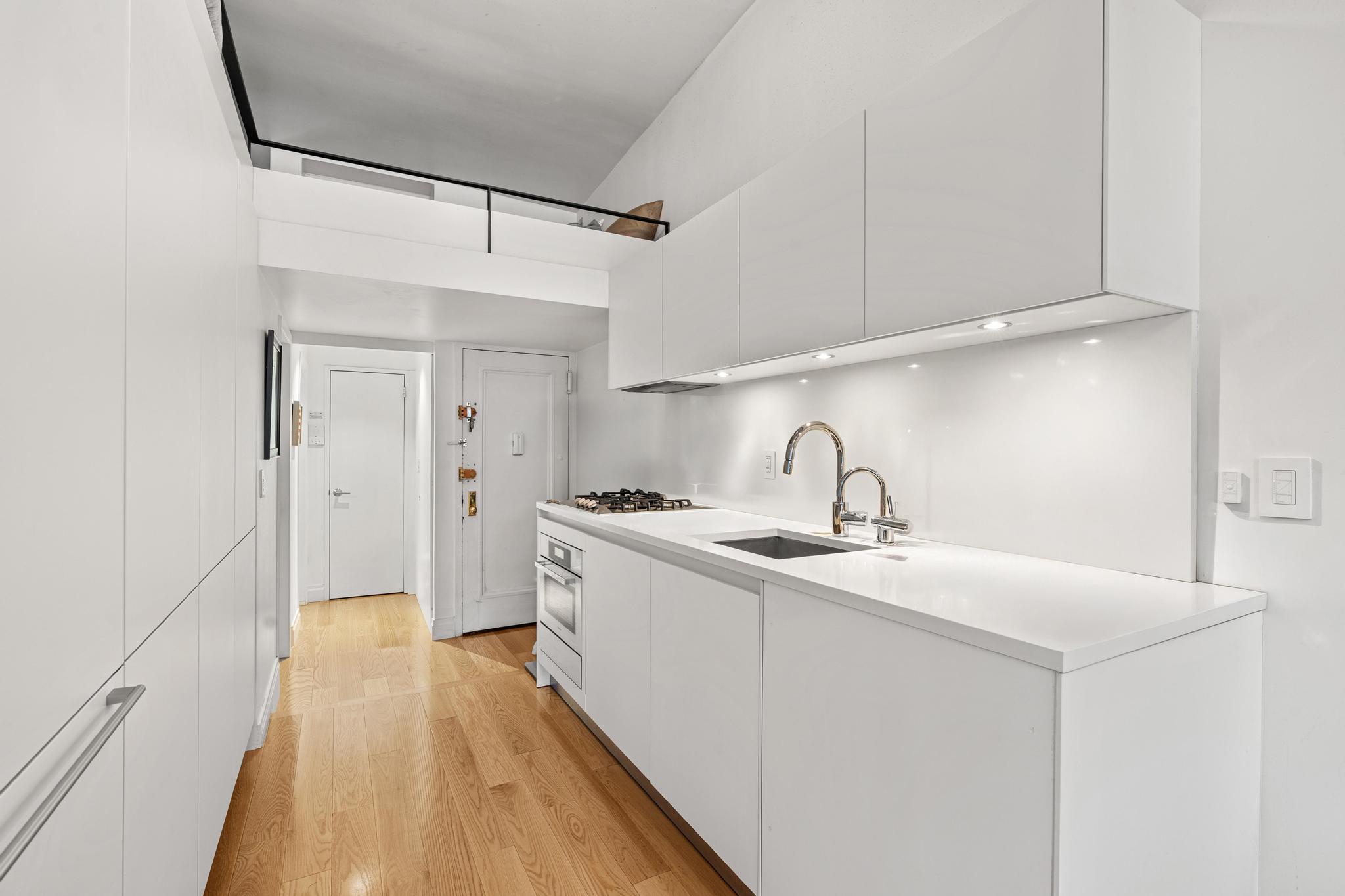 143 Sullivan Street, Unit 16 Manhattan, NY 10012 - Photo 3 of 10 a kitchen with a sink and refrigerator