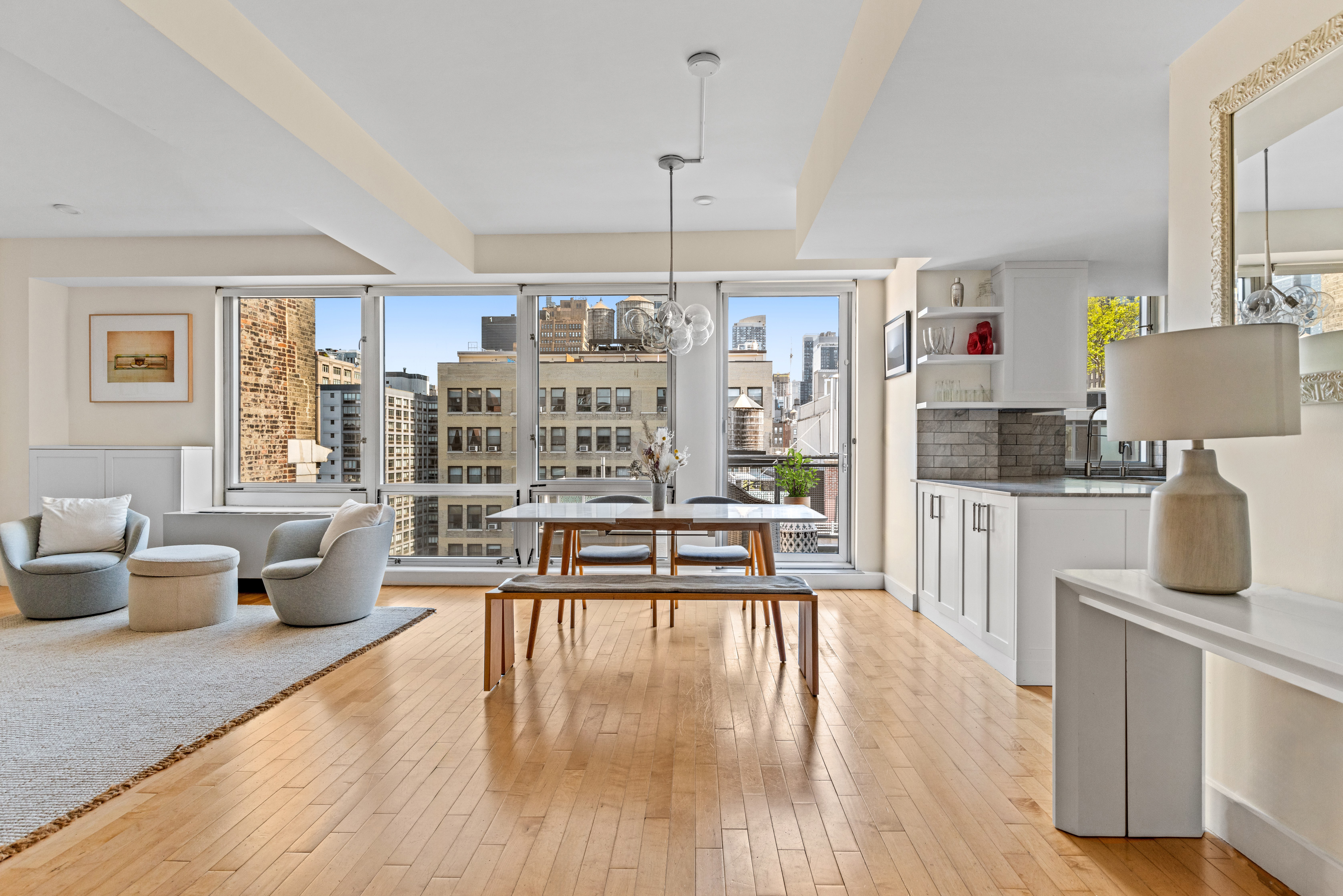 146-148 West 22nd Street, Unit PH Manhattan, NY 10011 - Photo 1 of 12 a living room with furniture and a wooden floor