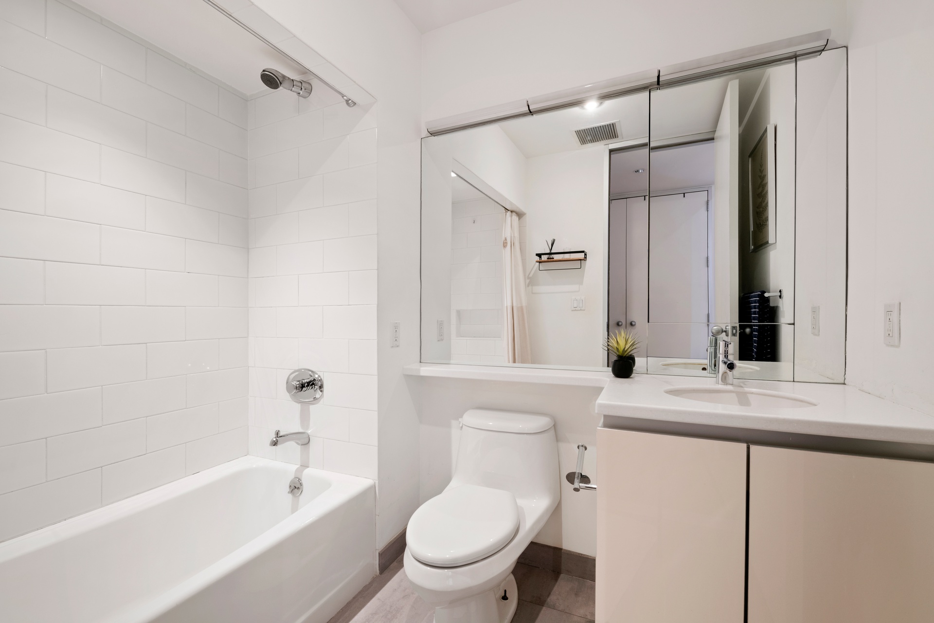 419 West 55th Street, Unit 2D Manhattan, NY 10019 - Photo 8 of 10 a bathroom with a granite countertop sink mirror toilet and bathtub