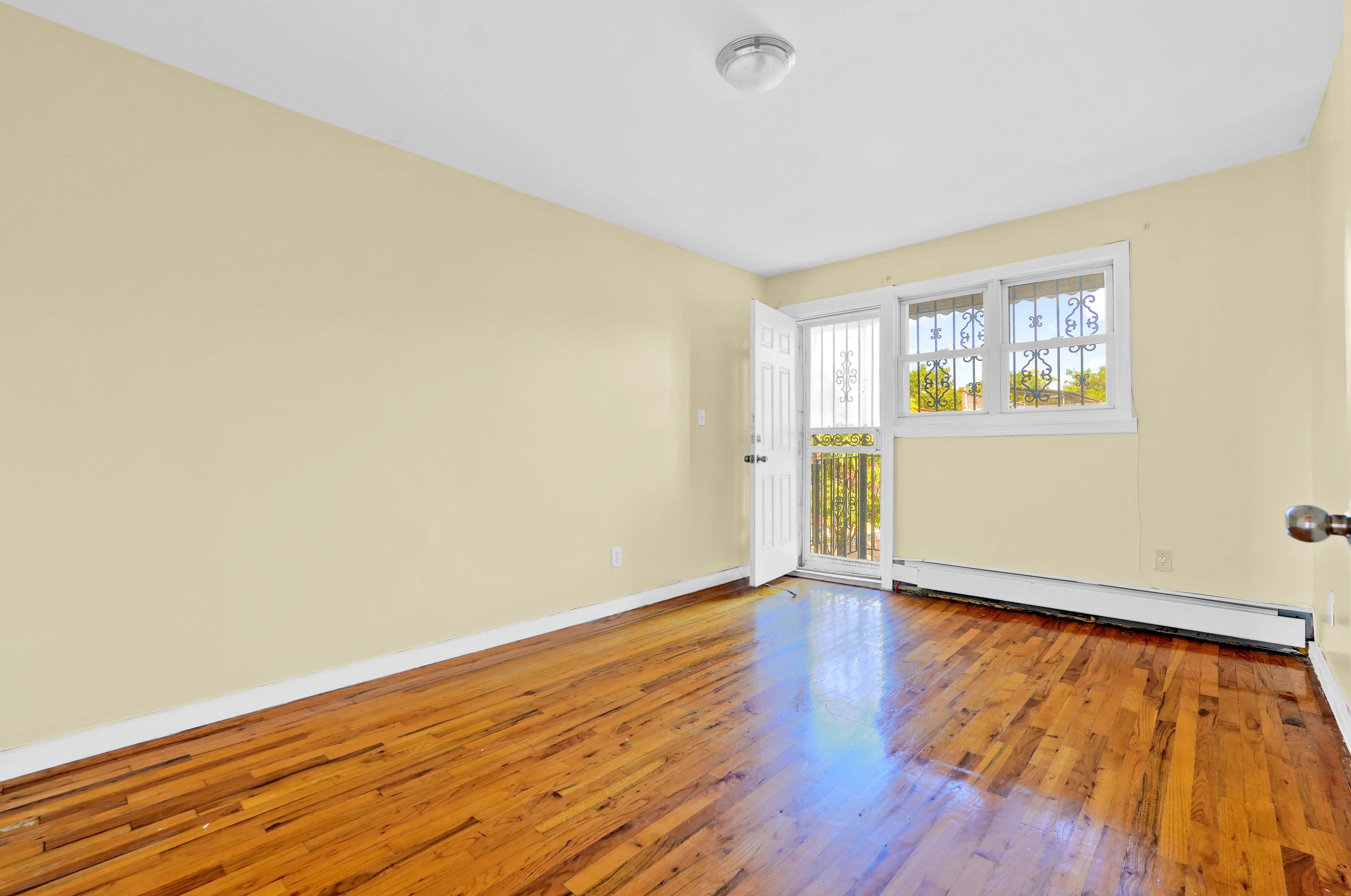 659 Jerome Street Brooklyn, NY 11207 - Photo 19 of 39 an empty room with wooden floor and windows