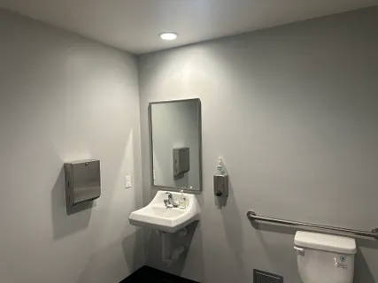 a bathroom with a toilet sink and mirror