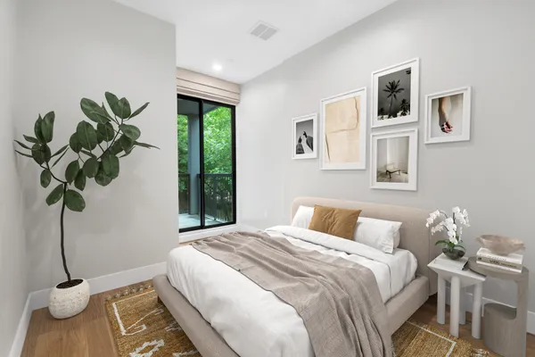 a bedroom with a bed a window and potted plant