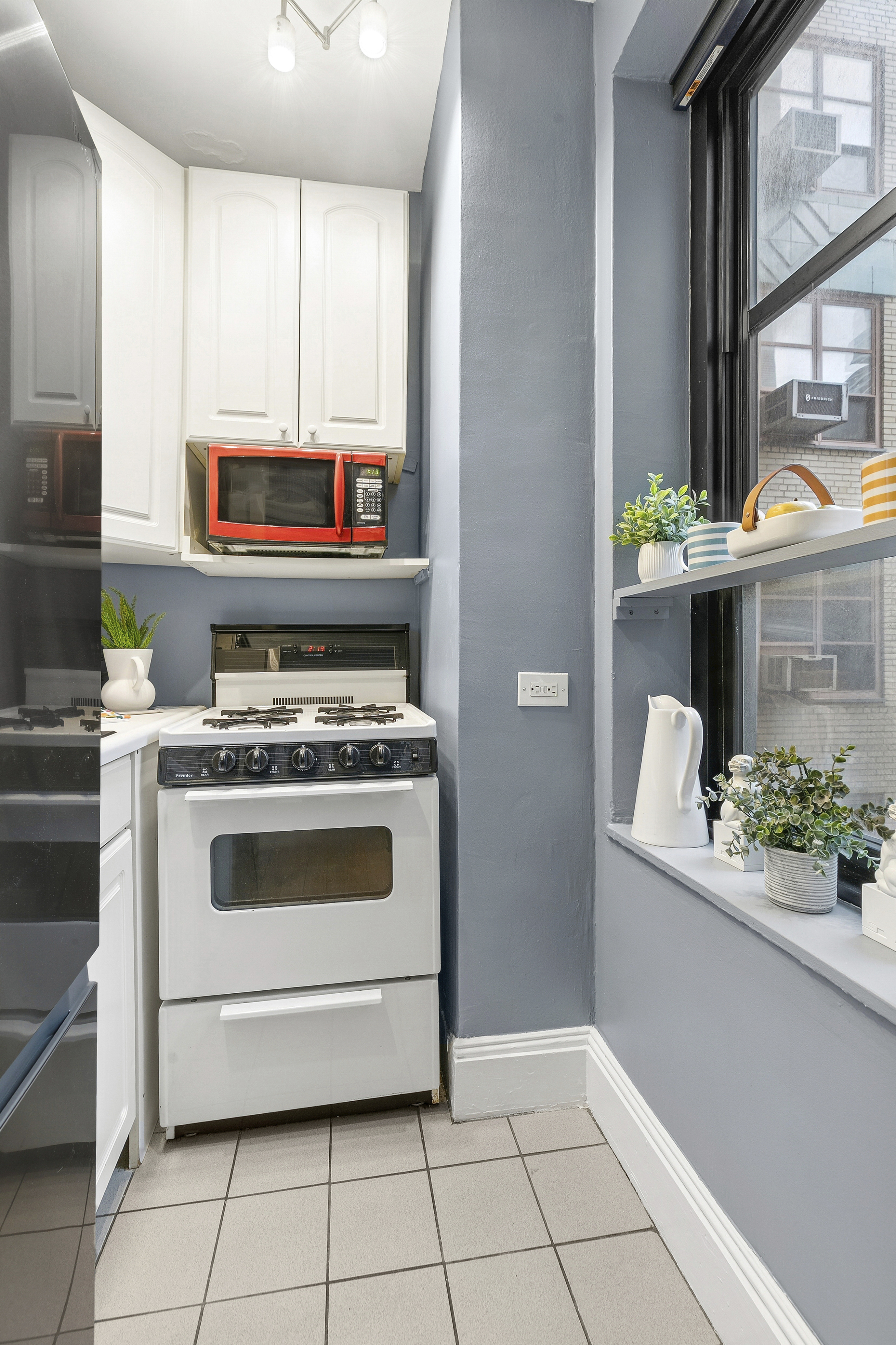 235 East 22nd Street, Unit 4M Manhattan, NY 10010 - Photo 5 of 14 a kitchen with stainless steel appliances a stove a microwave and cabinets