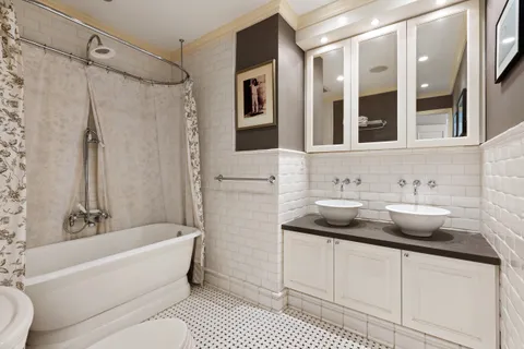a bathroom with a granite countertop sink and a mirror a bathtub