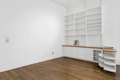 a room with a white walls and wooden floors